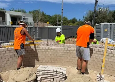 Tradesmen carefully installing bricks on a residential wall
