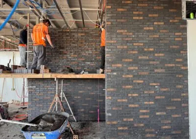 Detailed dark brick feature wall being built inside a modern property
